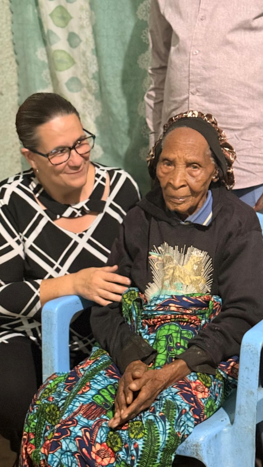 Young volunteer sitting with an elder community member